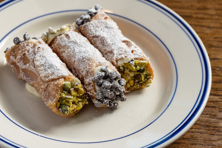 Three cannoli desserts on a plate